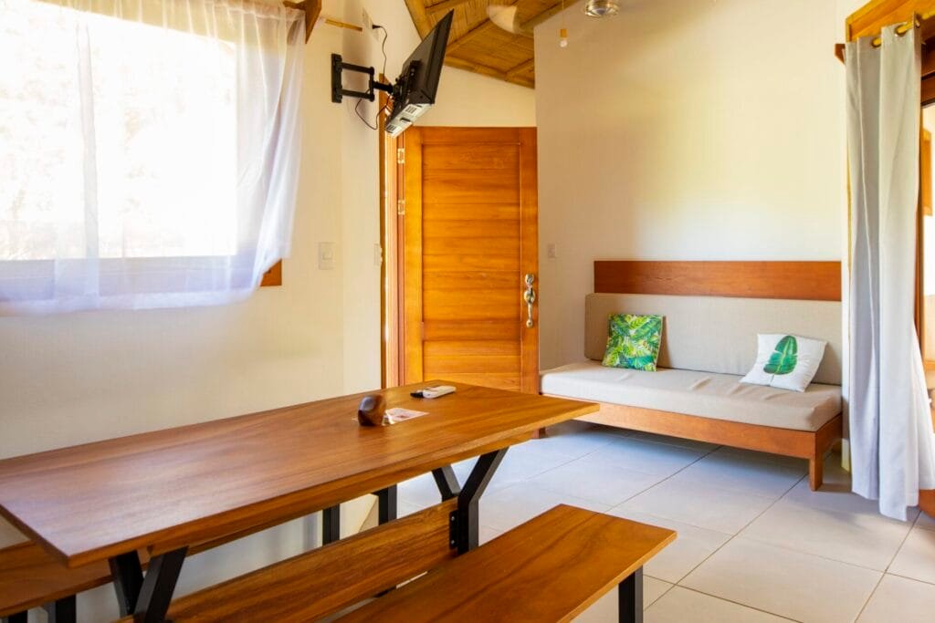 Interior de una habitación acogedora con una mesa de madera, un sofá y una ventana iluminada. Ideal para descansar y relajarse.