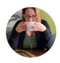 Mujer sosteniendo una taza de café, con un fondo colorido y una expresión concentrada, en un ambiente acogedor.