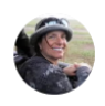 Mujer sonriente con sombrero, disfrutando de la naturaleza en un entorno al aire libre.