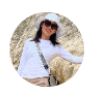 Mujer sonriendo con un sombrero blanco y camiseta de manga larga, posando frente a una roca. Ideal para contenido sobre moda de verano o actividades al aire libre.